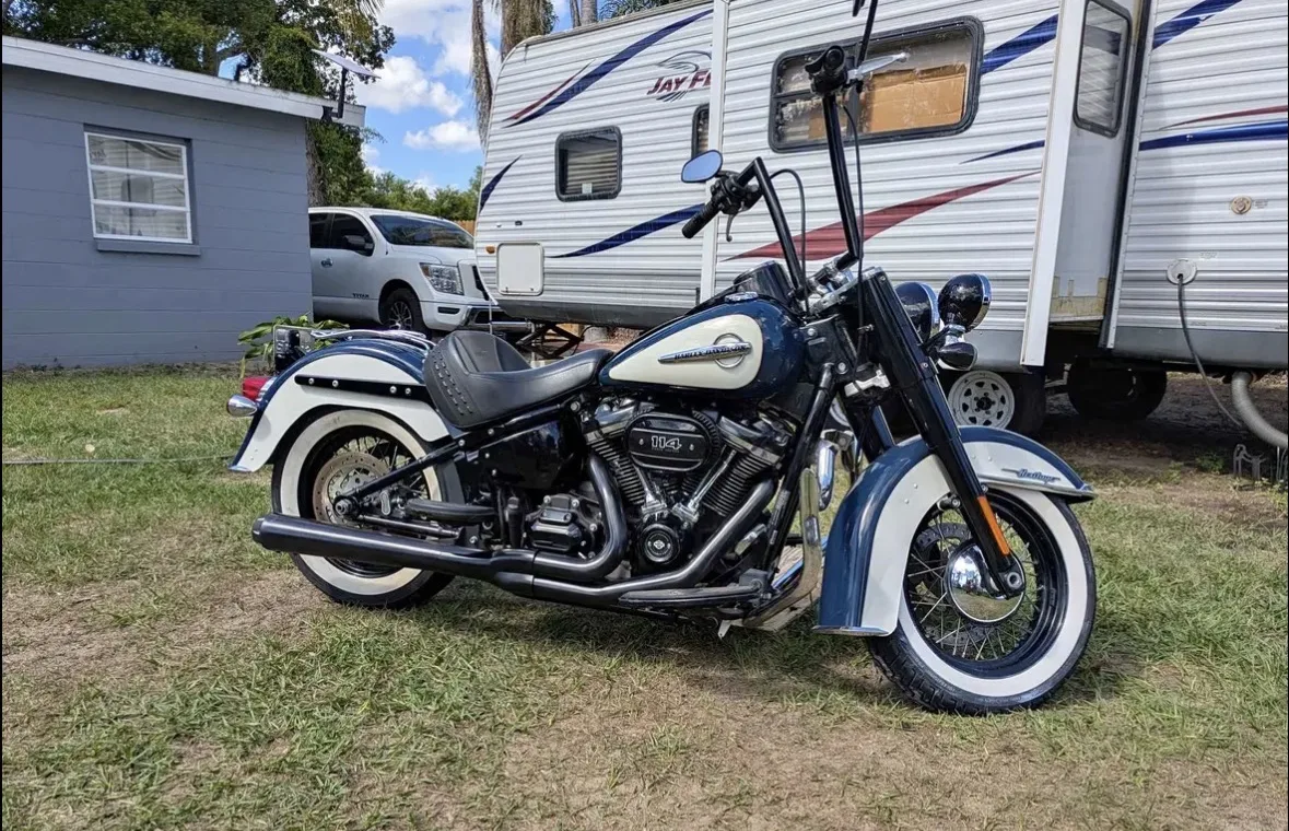 2019 Harley-Davidson Heritage Classic 114, two-tone blue and cream with black ape hangers, parked on grass in the sun