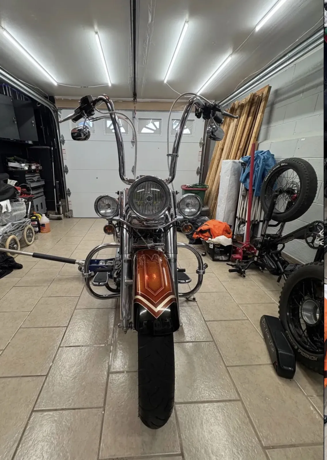 2005 Harley-Davidson Softail Deluxe, copper flake paint with black pinstriped fenders, parked outside a house