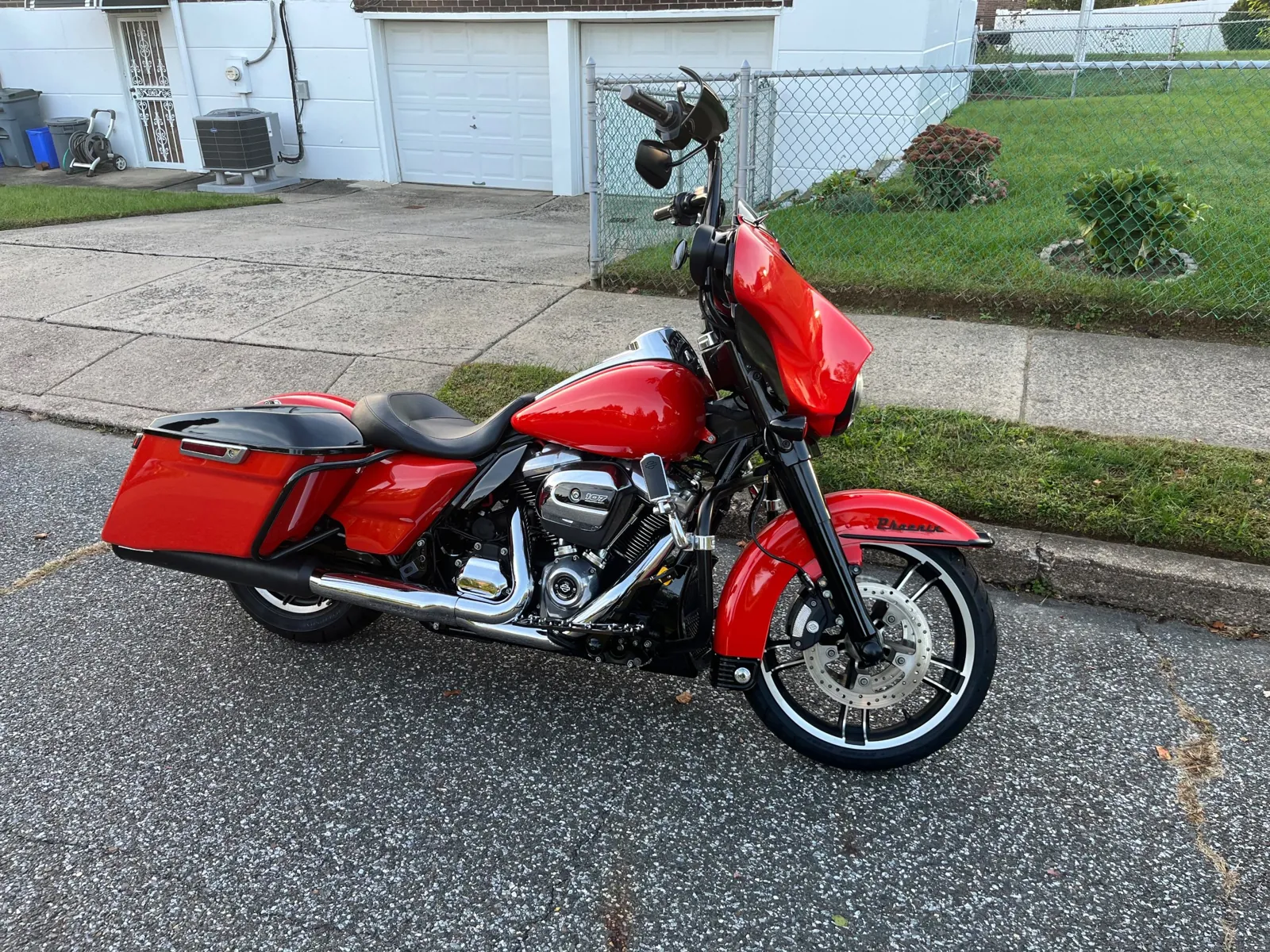 2019 Harley-Davidson Street Glide in bright red with gloss black saddlebag lids and tall black bars, side profile on the street